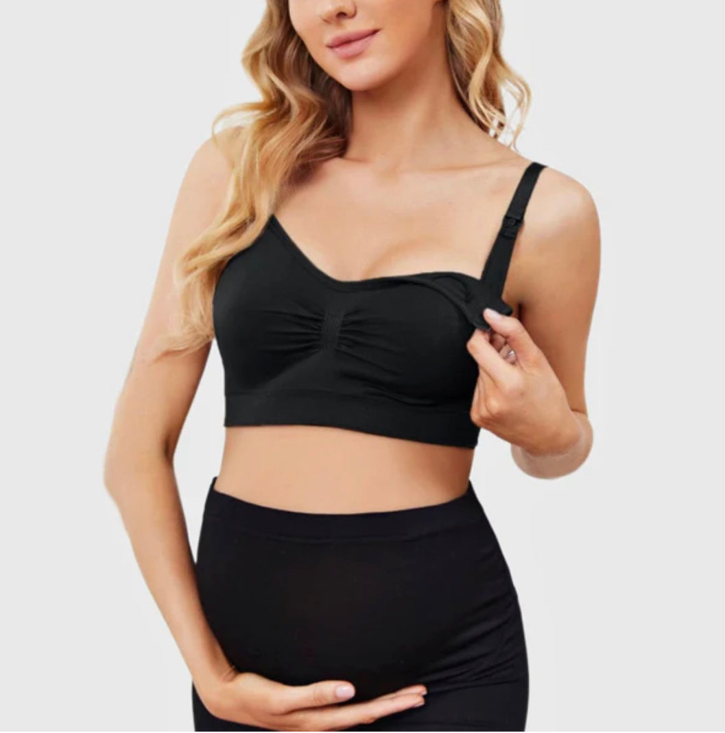 Woman wearing a black maternity bra on a plain background